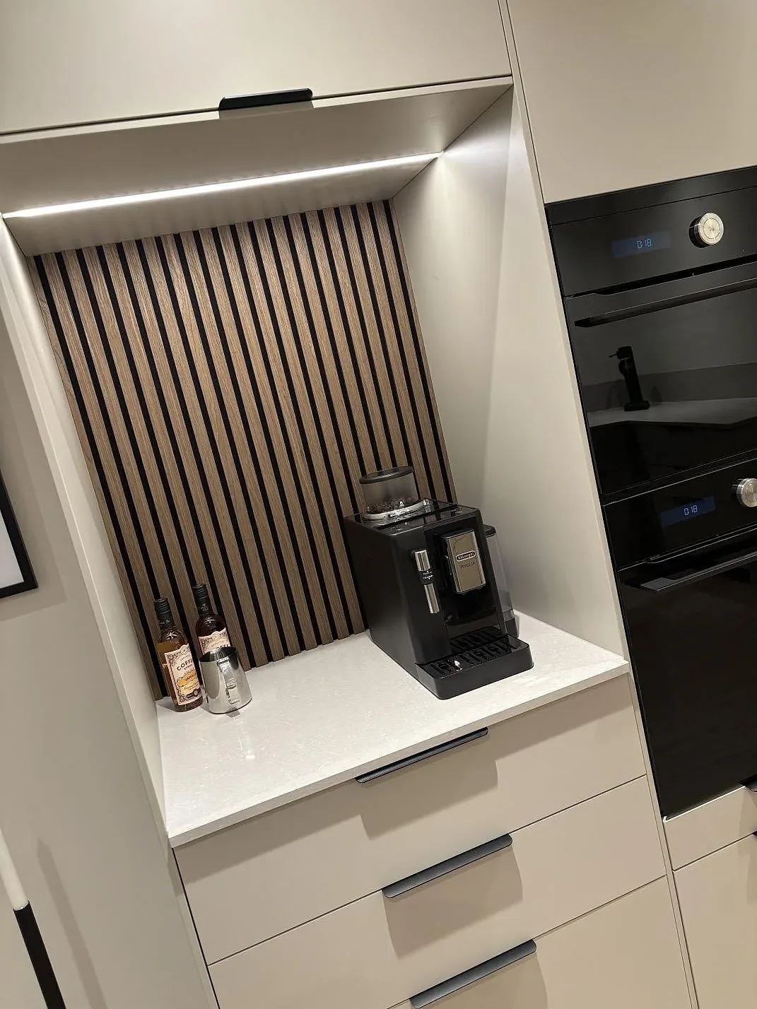 Bänkyta i polerad Technistone Noble Ivory White vid kaffestation och ljusa köksluckor i Gnosjö.