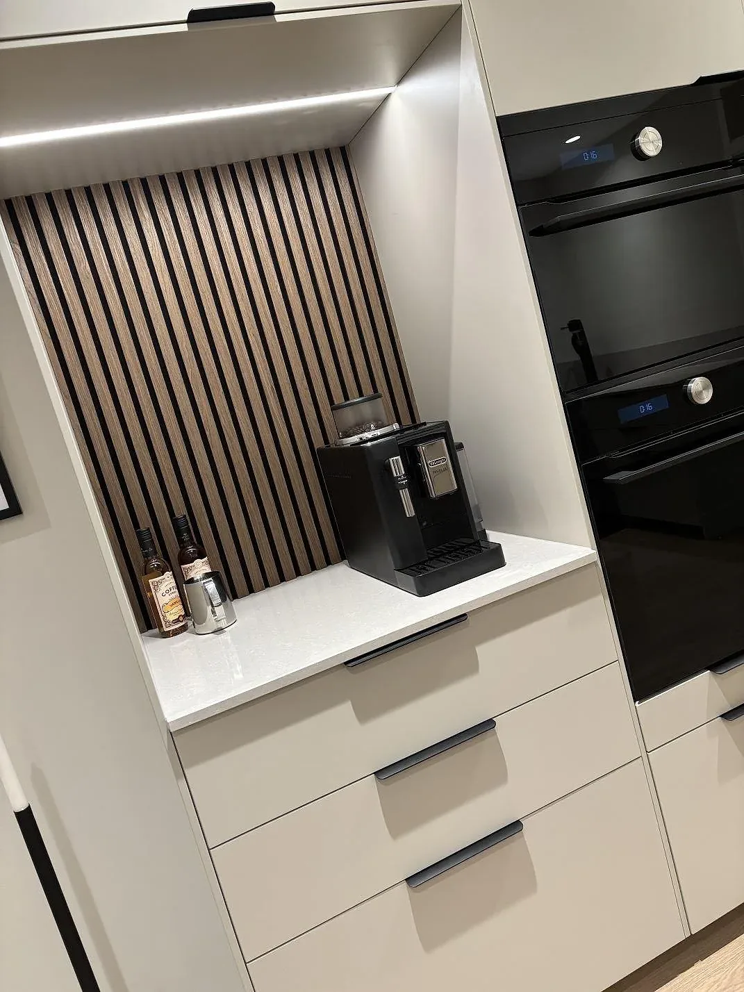 Polerad Technistone Noble Ivory White som bänkskiva i en belyst köksnisch med förvaring i Gnosjö.