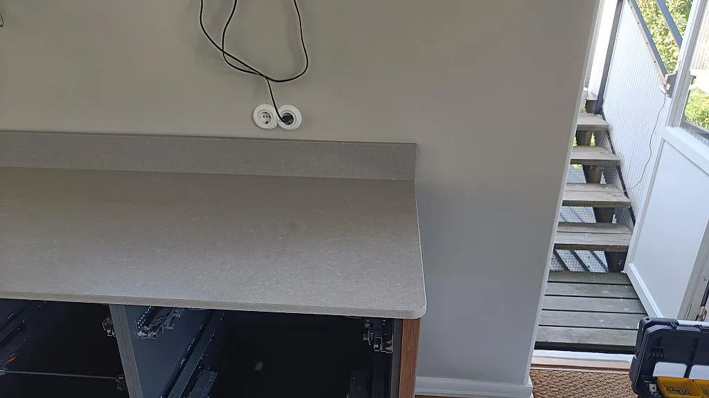 Sidosektion av köksbänkskiva i polerad Technistone Noble Ivory White intill fönster och dörr i Göteborg.