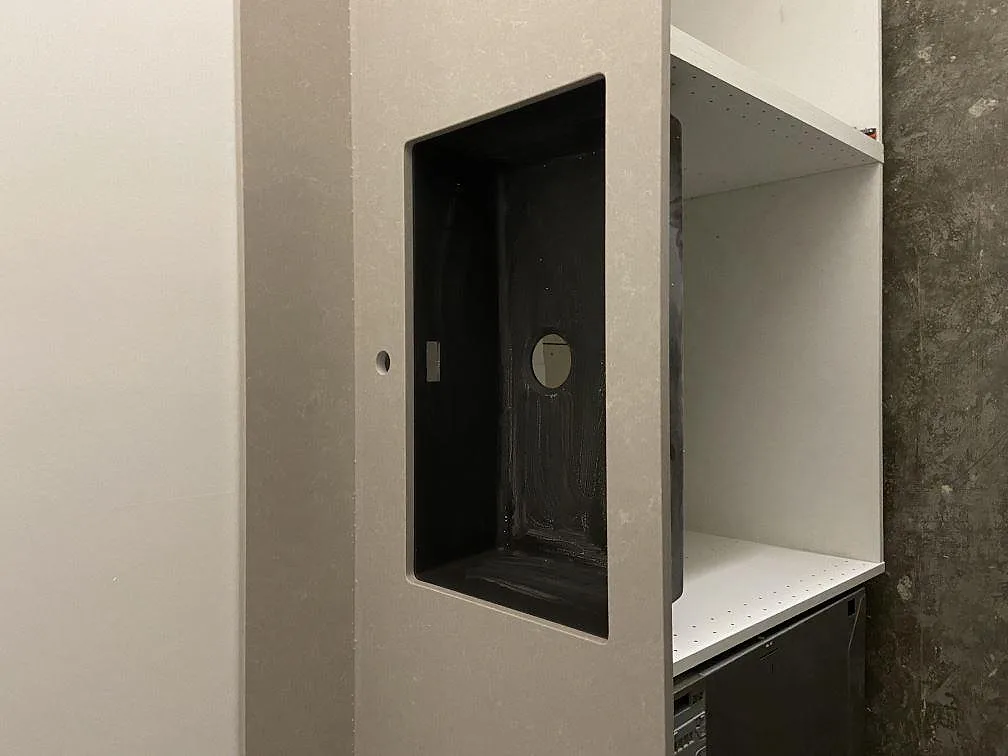 Installerad vit köksbänk i Technistone Noble Ivory White med uppvikt stänkskydd i ett kök i Habo.