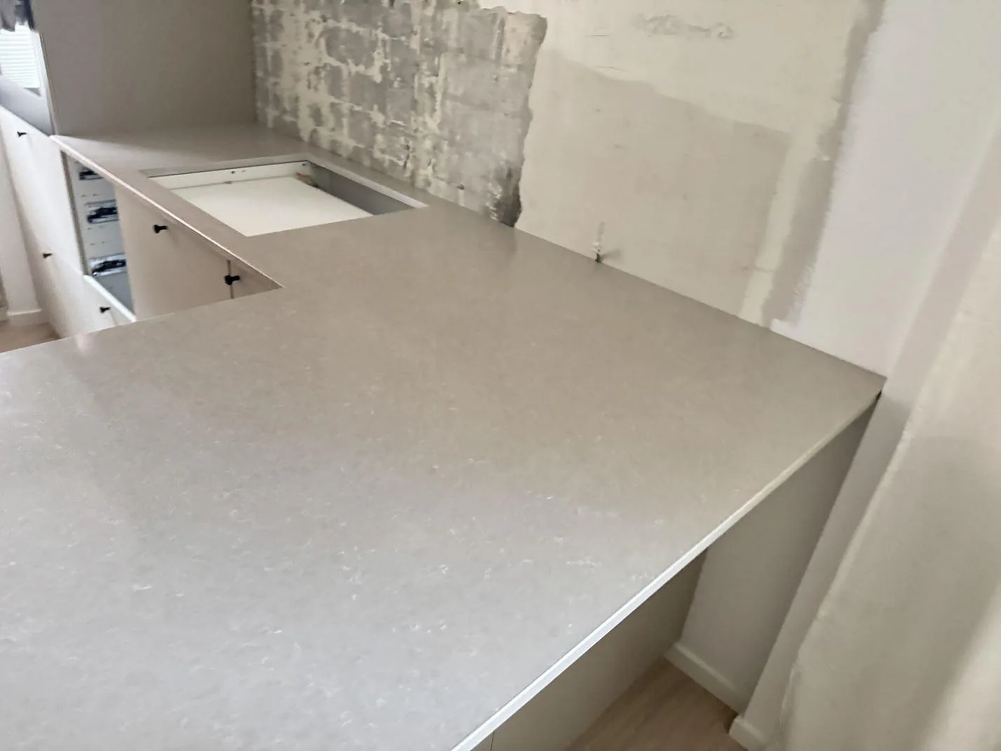 Halvö med köksbänkskiva i Technistone Noble Ivory White, polerad kvartskomposit med ljus gråbeige teckning, i Helsingborg.