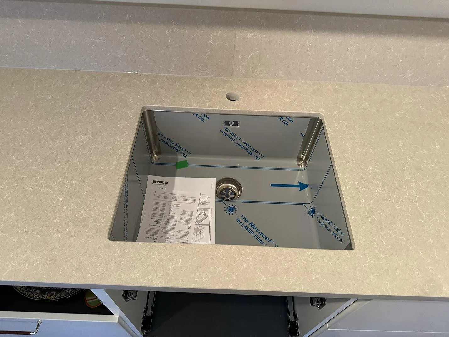 Närbild på underlimmad diskho i köksbänkskiva av polerad Technistone Noble Ivory White i Höllviken.
