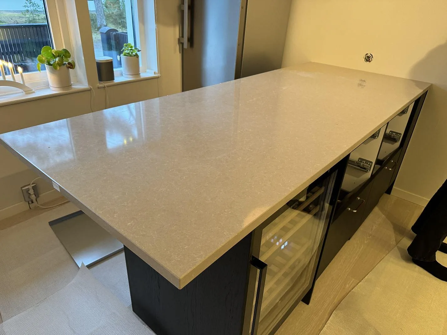 Köksö eller bordsskiva i polerad Technistone Noble Ivory White, ljus kvartskomposit, vid fönster i ett kök i Höllviken.