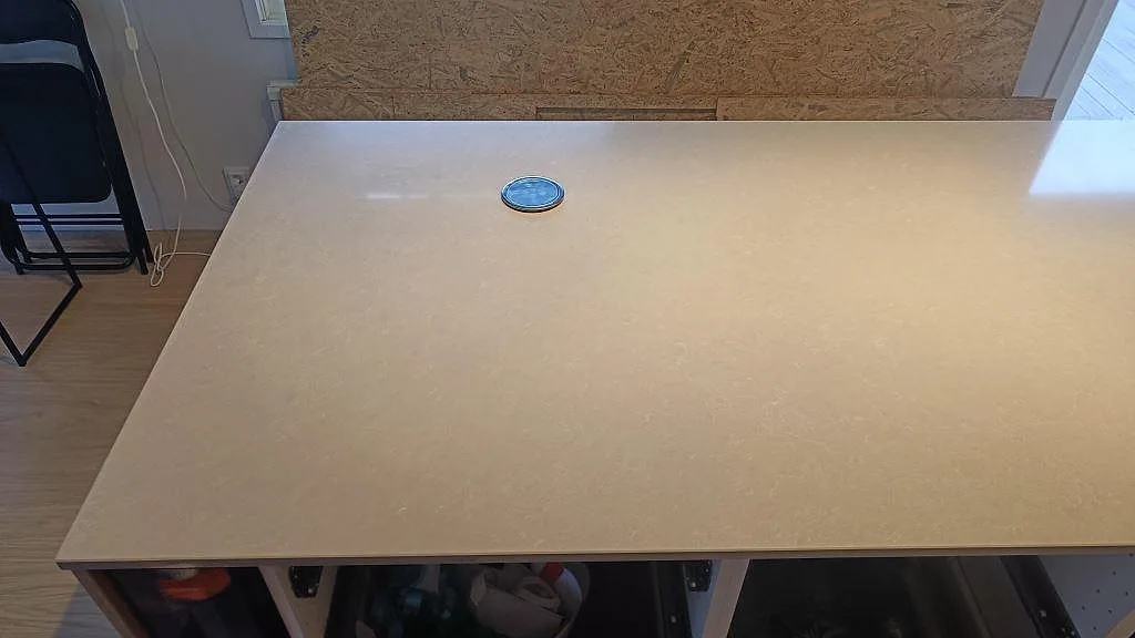 Stor köksö i ljus polerad Technistone Noble Ivory White med synlig stenstruktur i Höllviken.