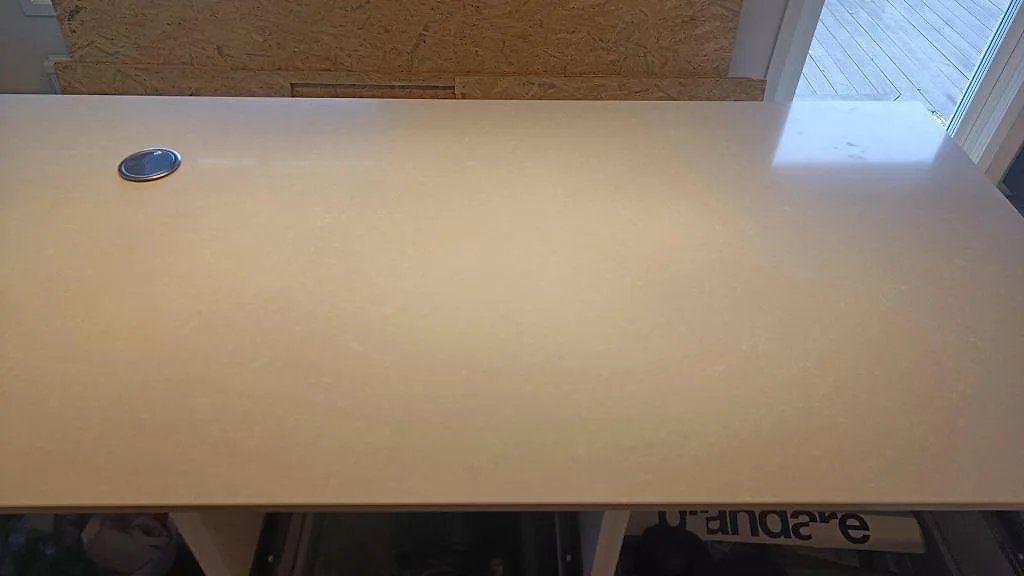 Detalj av köksö i polerad Technistone Noble Ivory White med mjuk ivoryton och öppna stommar i Höllviken.