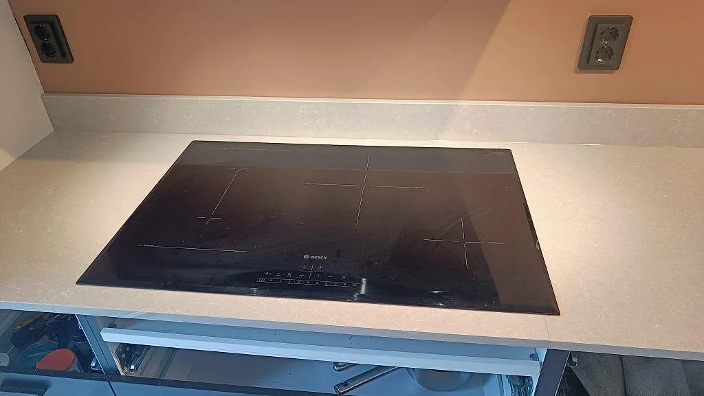 Polerad köksbänkskiva i Technistone Noble Ivory White med infälld häll och ljus stänkkant i Höllviken.