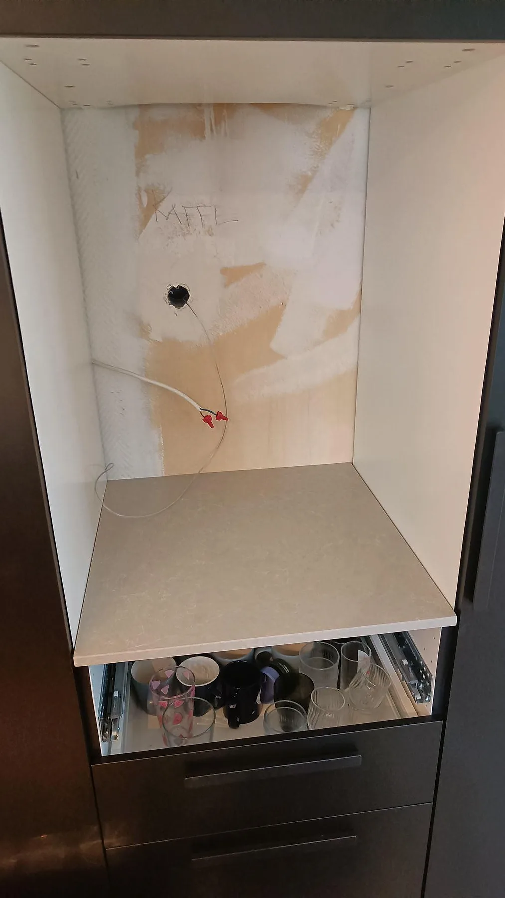 Installerad mindre bänkskiva i polerad Technistone Noble Ivory White i ett högskåp i Höllviken.