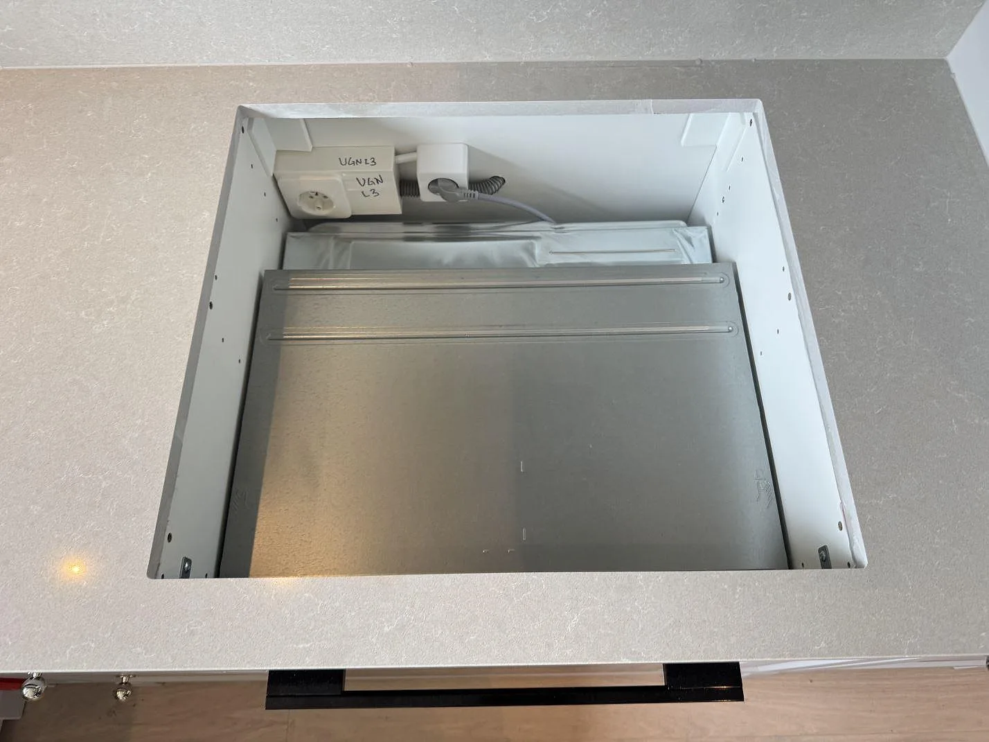 Närbild på hällurtag i polerad Technistone Noble Ivory White komposit, 20 mm bänkskiva under montering i Höllviken.