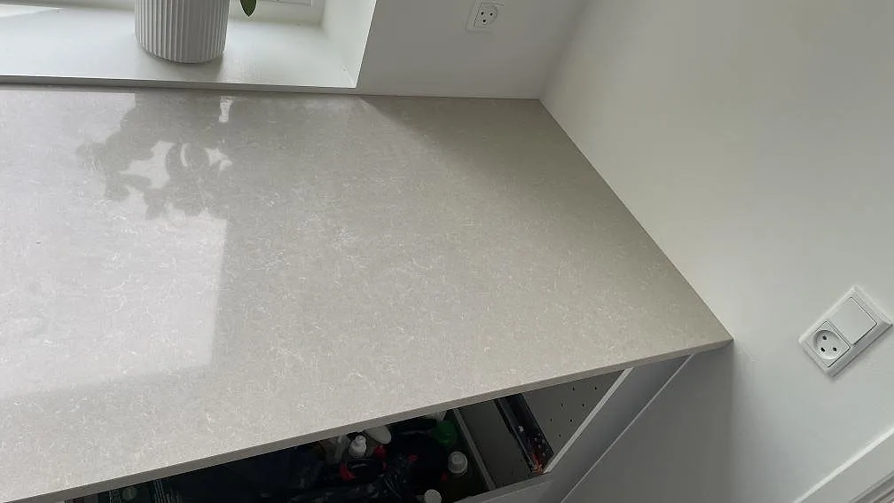 Detalj av den polerade Technistone Noble Ivory White bänkskivan med ljus ådring och fönsterkant i Hørsholm.