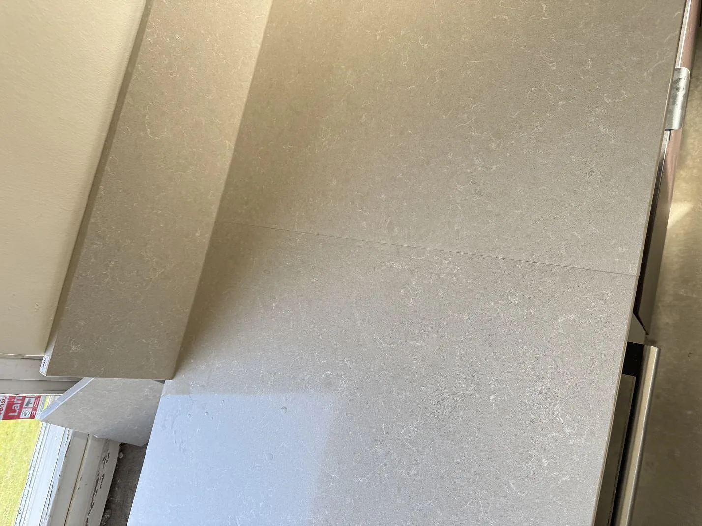 Detalj av polerad Technistone Noble Ivory White i kvartskomposit som visar den ljusa mönstringen på köksbänkskivan i Hovås.