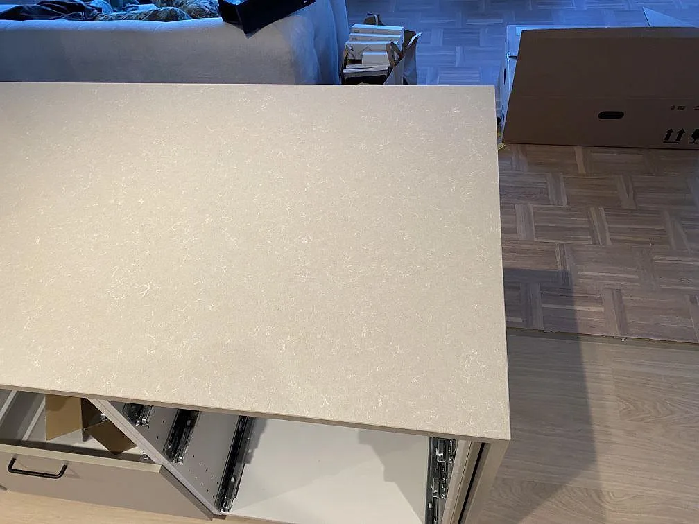 Närbild av köksbänkskiva i polerad Technistone Noble Ivory White komposit med synlig kant och öppen stomme i Jönköping.