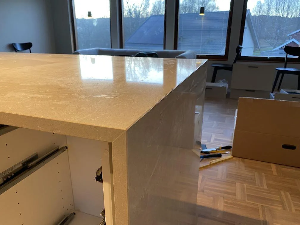 Närbild på polerad Technistone Noble Ivory White komposit med blank topp och sidostycke på en köksarbetsdel i Jönköping.