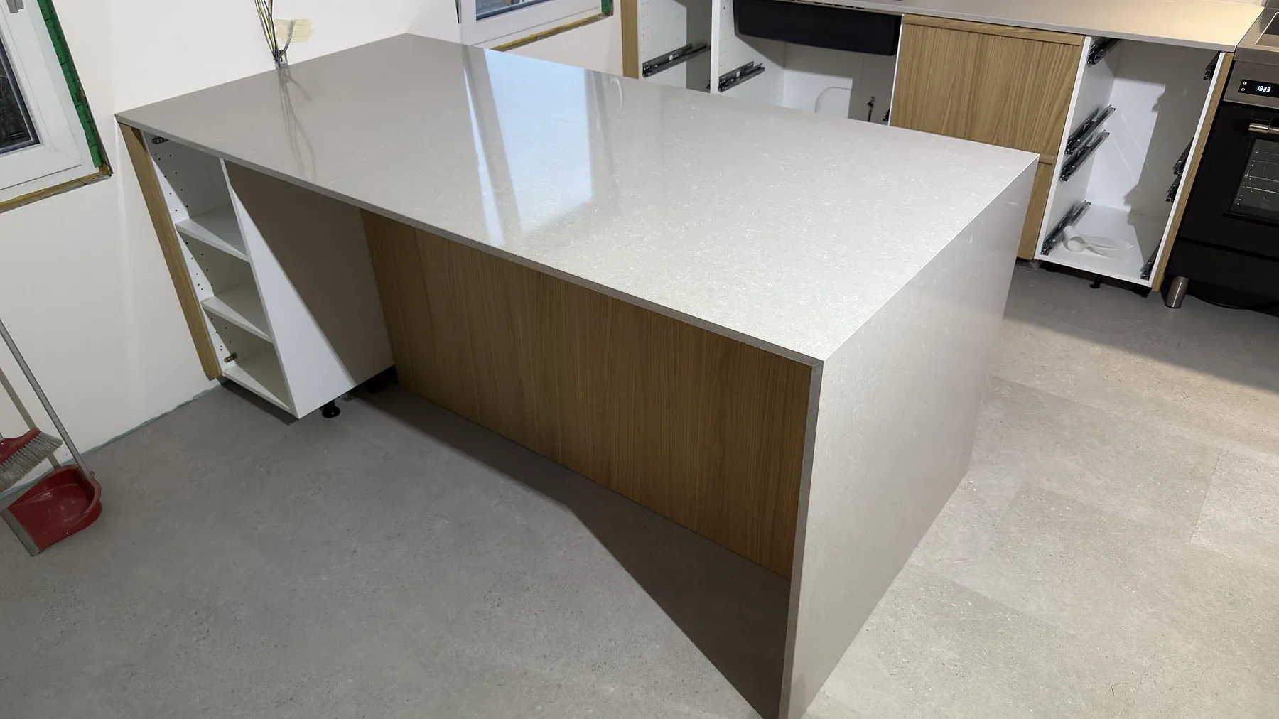 Närbild på köksö med polerad Technistone Noble Ivory White i 20 mm kvartskomposit och neddragen gavel i Karlskoga.