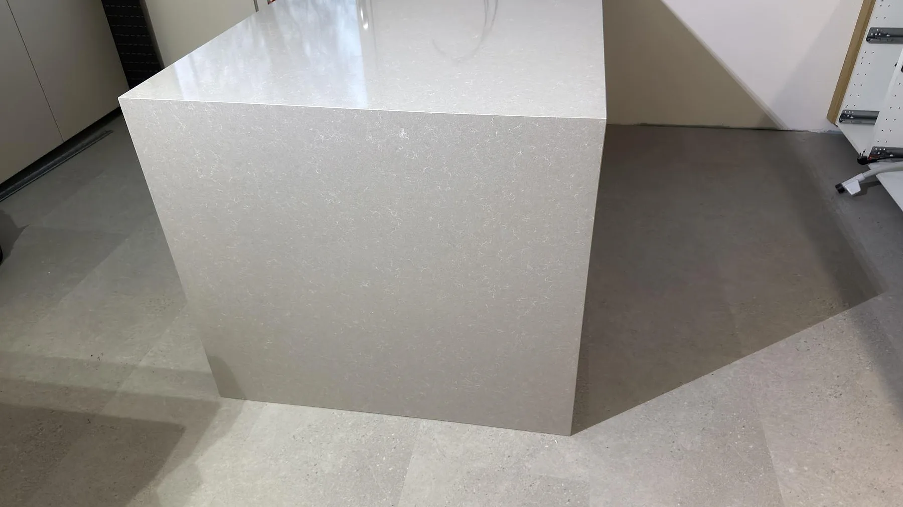 Närbild på neddragen gavel i polerad Technistone Noble Ivory White som visar den ljusa kompositens mönster i Karlskoga.