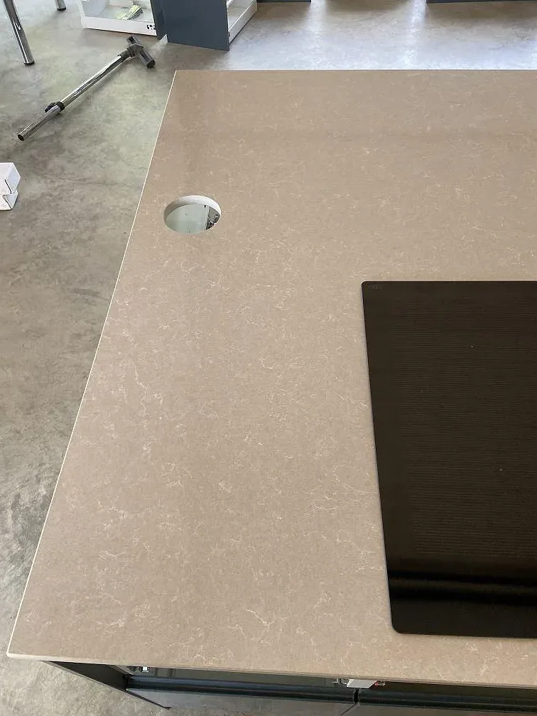 Närbild på den polerade ivory-ytan i Technistone Noble Ivory White med induktionshäll och borrat blandarehål i ett kök i Kivik.
