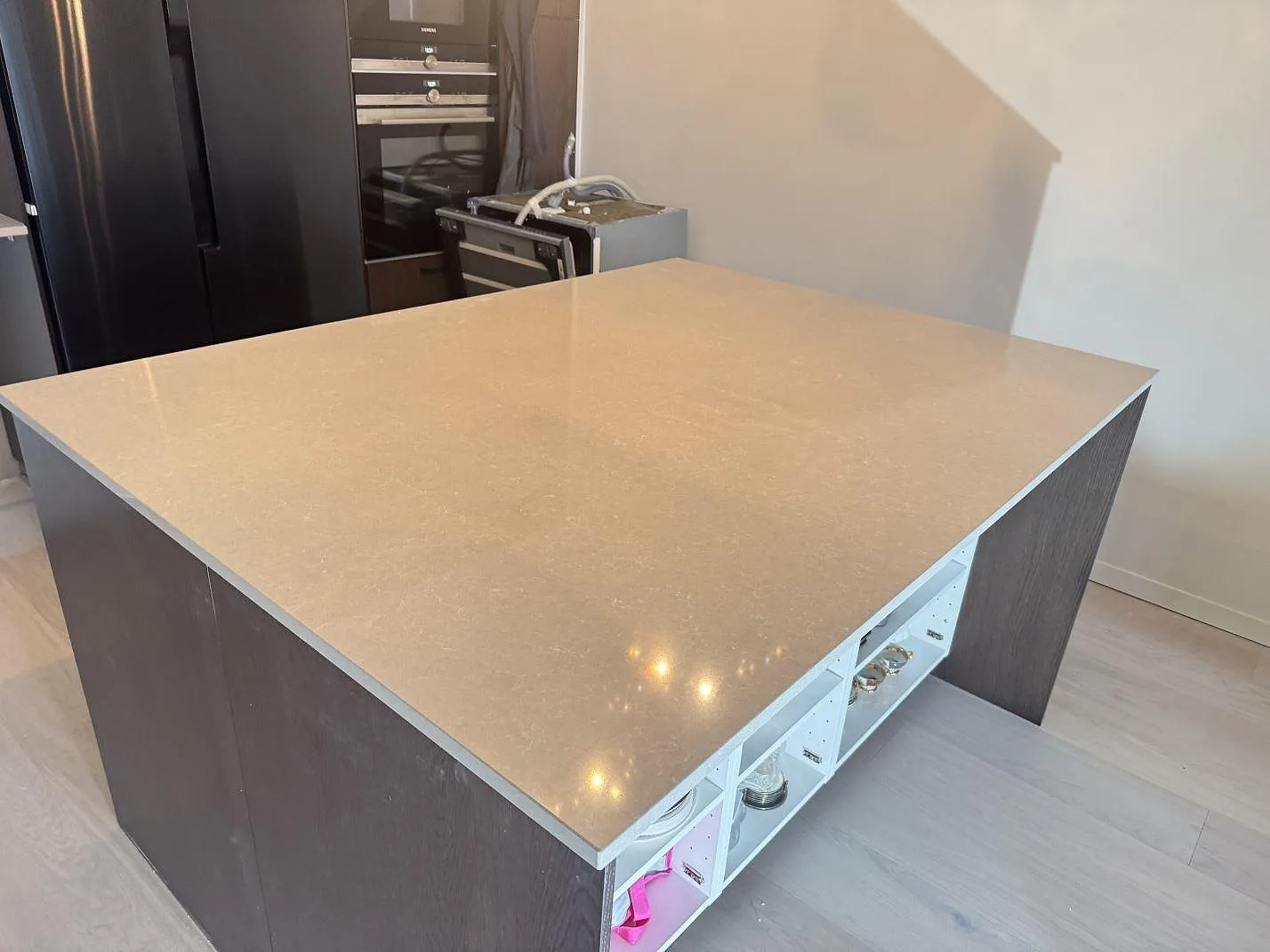 Stor köksö med polerad Technistone Noble Ivory White, 20 mm komposit, monterad på mörka köksstommar i Kungsbacka.