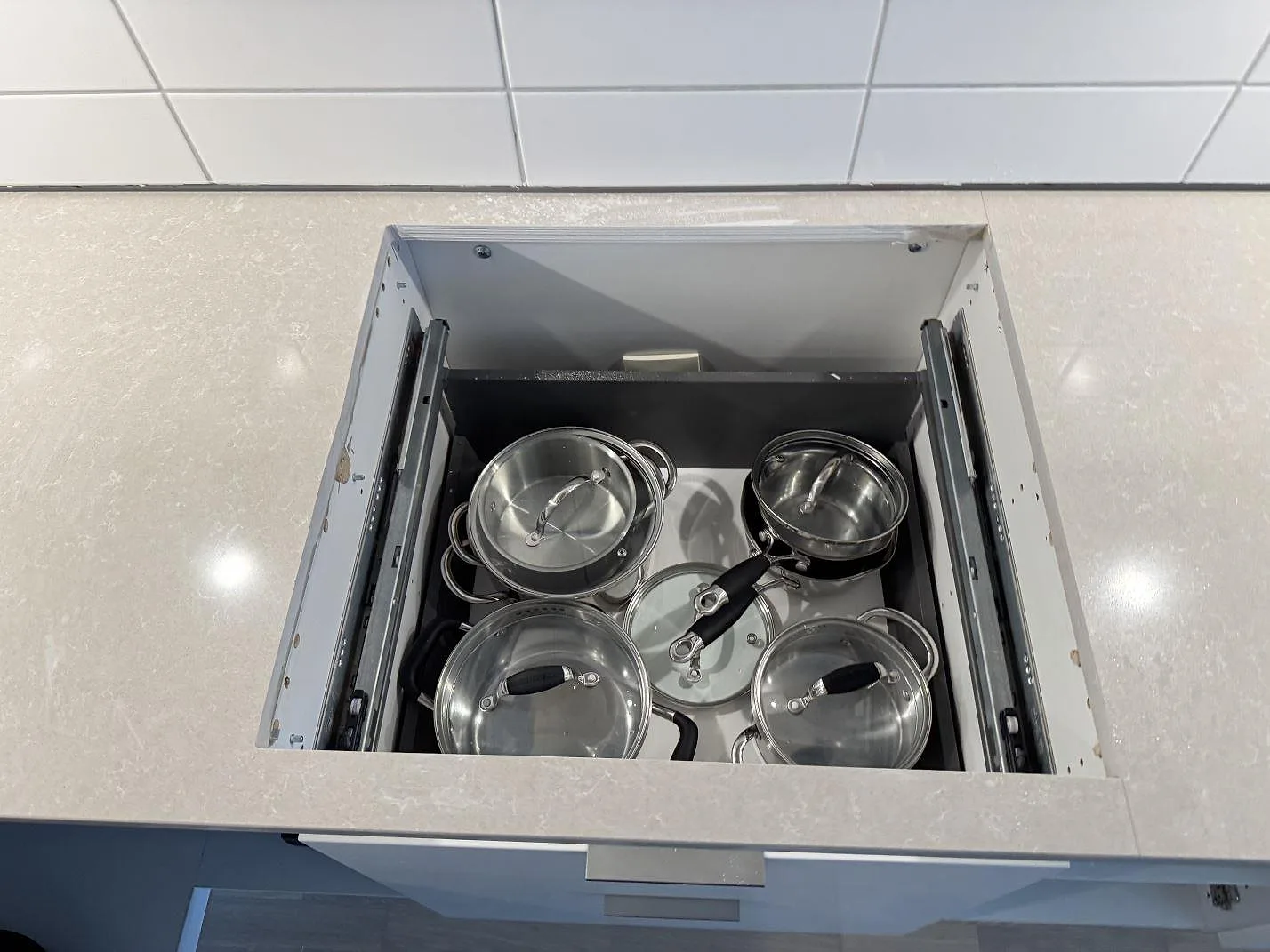 Detalj av hällurtag i en ljus, polerad Technistone Noble Ivory White köksbänkskiva under montering i Landskrona.
