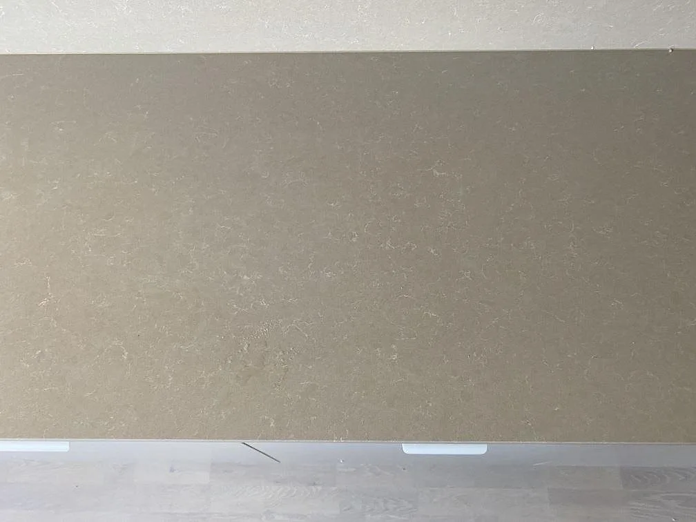 Närbild ovanifrån av polerad Technistone Noble Ivory White, komposit, med ljus stenbild på köksbänkskiva i Lomma.