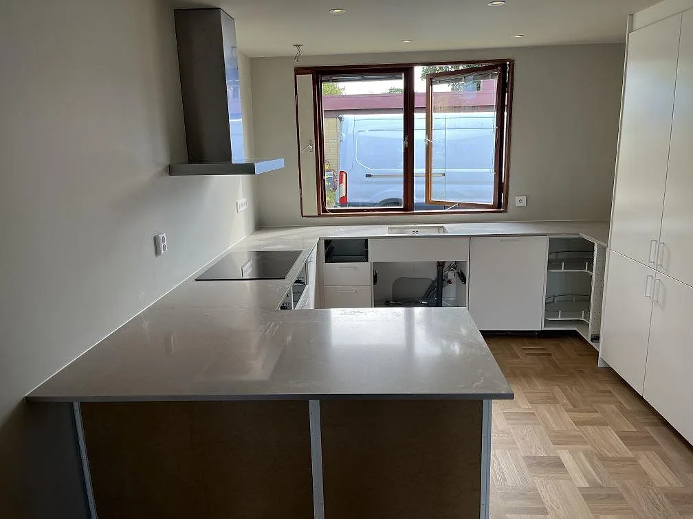 Ovanifrån på köksbänkskiva i Technistone Noble Ivory White med synlig ådring och skarv, ljusgrå kvartskomposit i ett kök i Malmö.