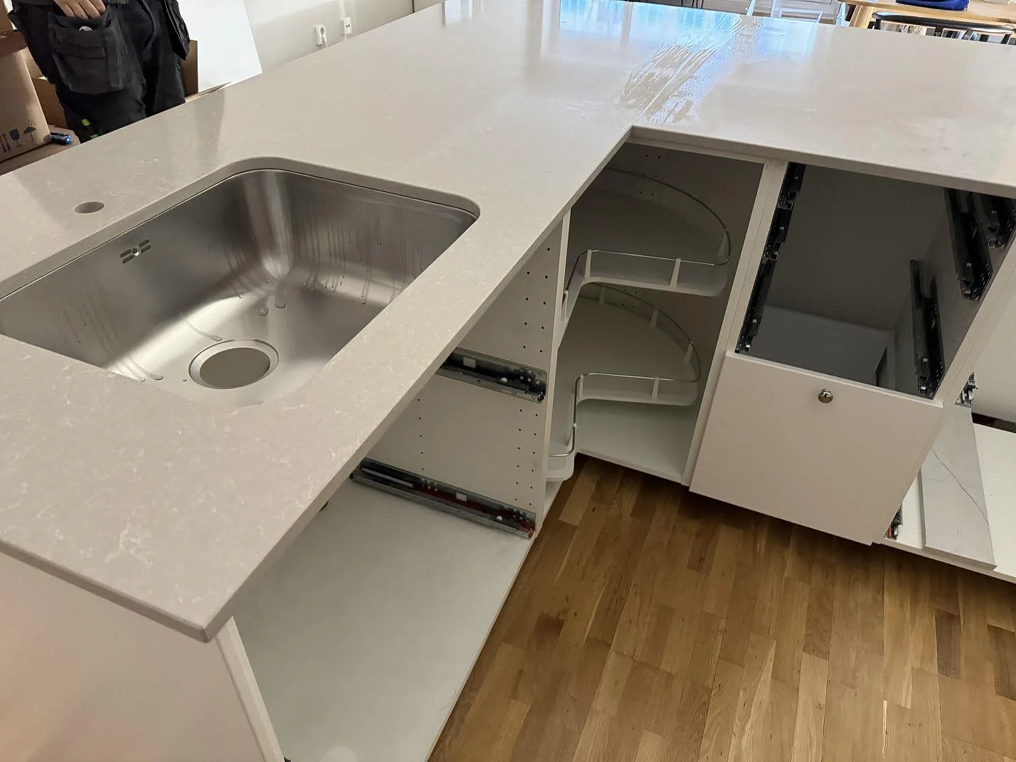 Underlimmad rostfri diskho i bänkskiva av polerad Technistone Noble Ivory White, fotograferad under montering i ett kök i Malmö.