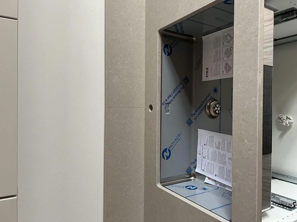 Detalj av diskhoöppning och blandarhål i Technistone Noble Ivory White komposit vid montering i Malmö.