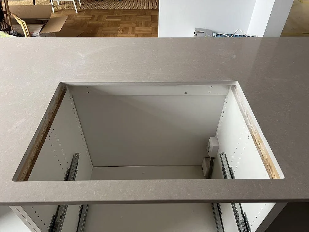 Närbild på diskhoöppning i en polerad kompositbänkskiva av Technistone Noble Ivory White i Malmö.