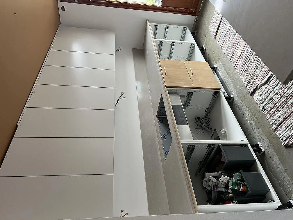 Översikt över polerad Technistone Noble Ivory White köksbänkskiva på vita köksstommar under montering i Malmö.