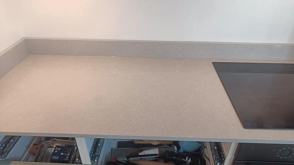 Hällsida med polerad köksbänkskiva i Technistone Noble Ivory White och uppvikt stänkkant i Malmö.