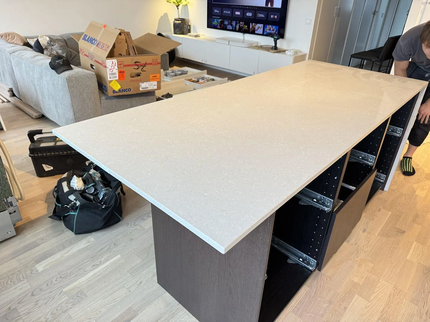 Stor köksö med bänkskiva i polerad Technistone Noble Ivory White, ljus kvartskomposit, sedd från rummet i Malmö.