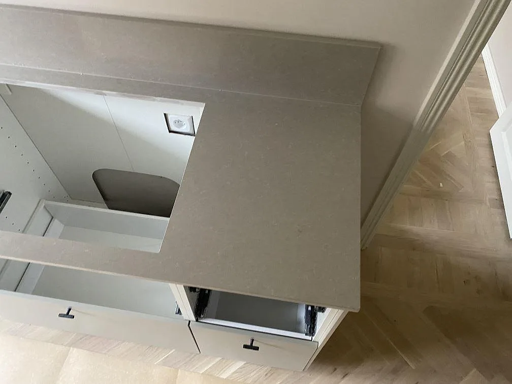 Sidovy av ljus Technistone Noble Ivory White som köksbänkskiva med urtag, retur och polerad yta under montering i Malmö.