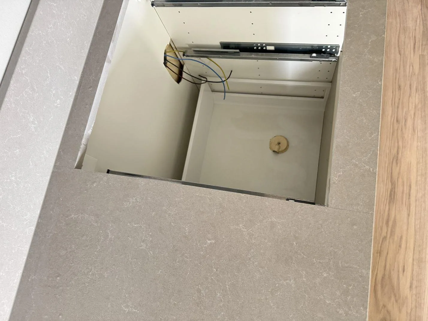 Närbild på öppen urskärning och ljus ådring i polerad Technistone Noble Ivory White bänkskiva i Malmö.