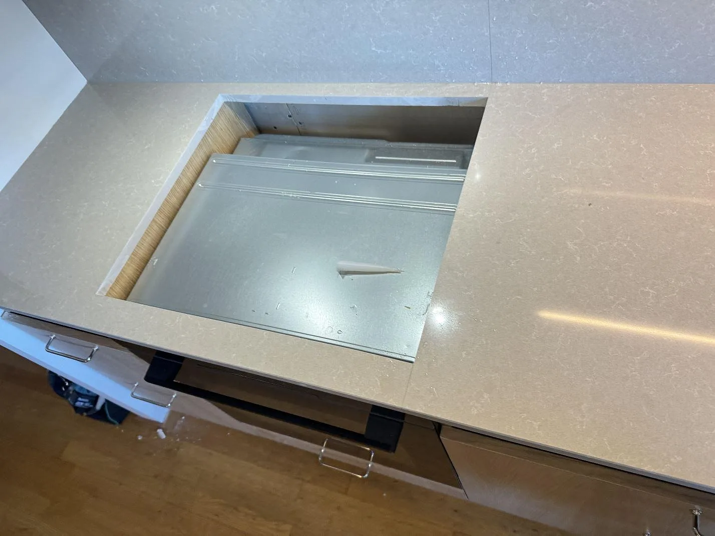 Hällurtag i polerad Technistone Noble Ivory White komposit med ljus ådring och stänkpanel bakom bänken i kök i Malmö.