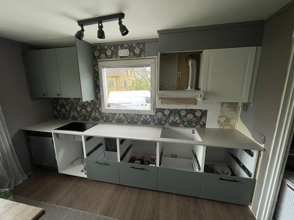 Köksbänkskiva i vit Technistone Noble Ivory White, polerad 20 mm komposit, monterad som rak bänkrad längs vägg och underskåp i Mölnbo.