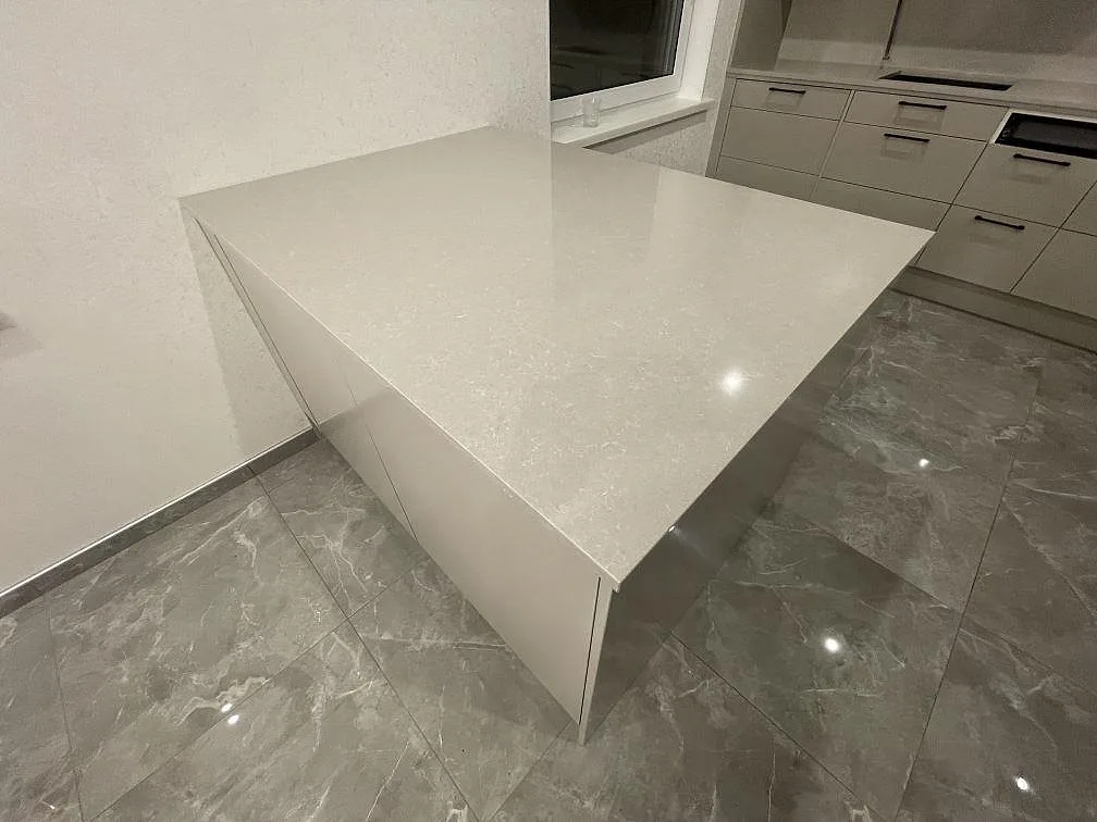 Närbild på den polerade köksön i Technistone Noble Ivory White som visar den mjuka, finkorniga elfenbensvita ådringen i ett kök i Norrköping.