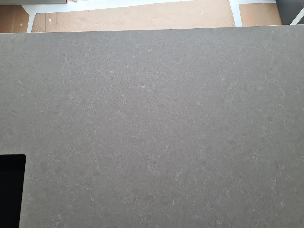 Polerad Technistone Noble Ivory White bänkskiva med diskhokant och ljus mönstring i ett kök under montering i Ösmo.