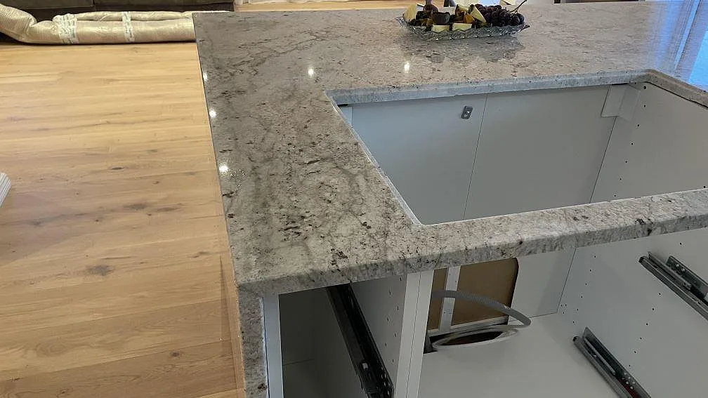 Bänkskiva i Technistone Noble Ivory White med utskärning för underlimmad diskho under montering i Oskarström.