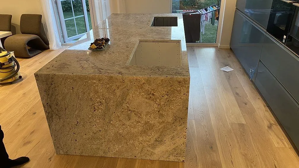 Monterad köksö i Technistone Noble Ivory White med neddragna sidor, polerad yta, diskho och häll i Oskarström.
