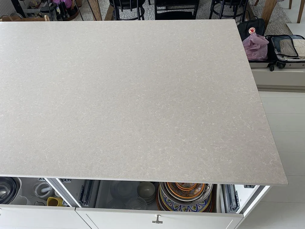 Närbild på köksöns skiva i polerad Technistone Noble Ivory White, ljus kvartskomposit med diskret mönster i Simrishamn.