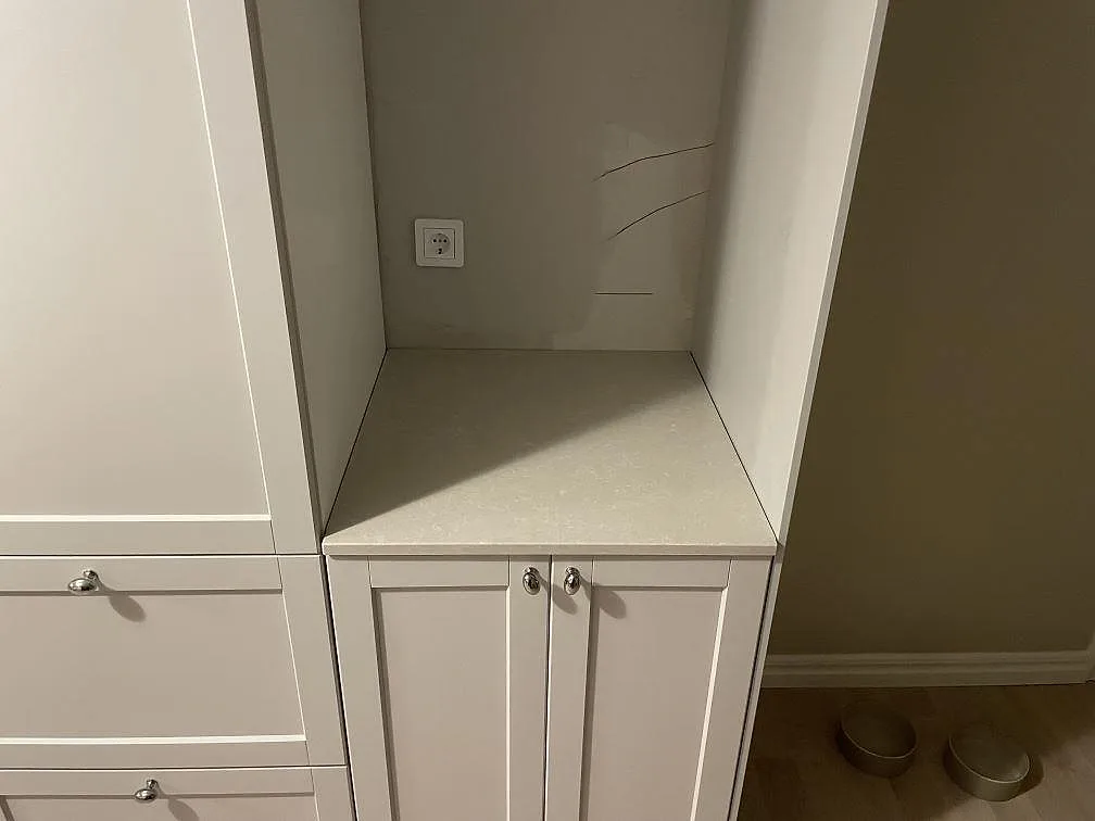 Bänkskiva i polerad Technistone Noble Ivory White kvartskomposit på en separat skåpsnisch i Skultuna.