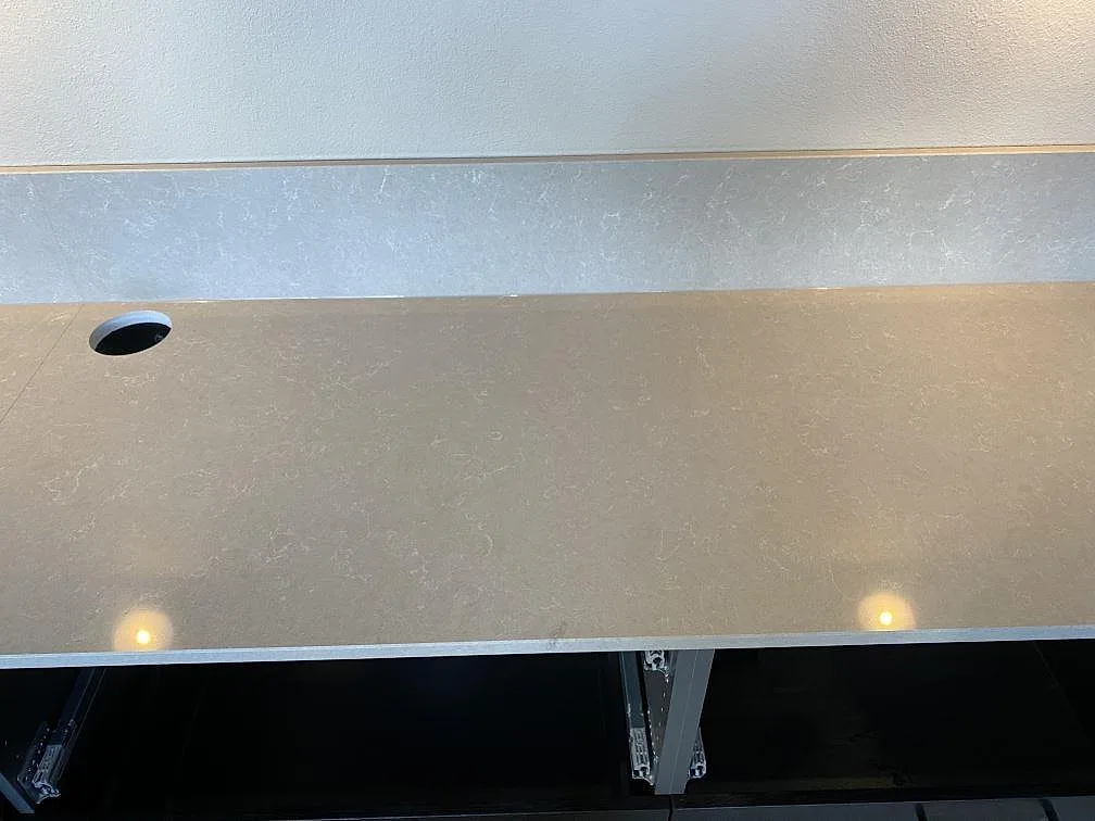 Köksö i Technistone Noble Ivory White med polerad yta och varm dagsljusreflex i ett kök i Staffanstorp.
