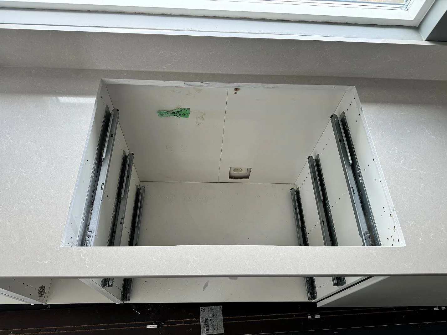 Hällöppning i köksbänkskiva av Technistone Noble Ivory White, polerad kvartskomposit, under montering i Staffanstorp.