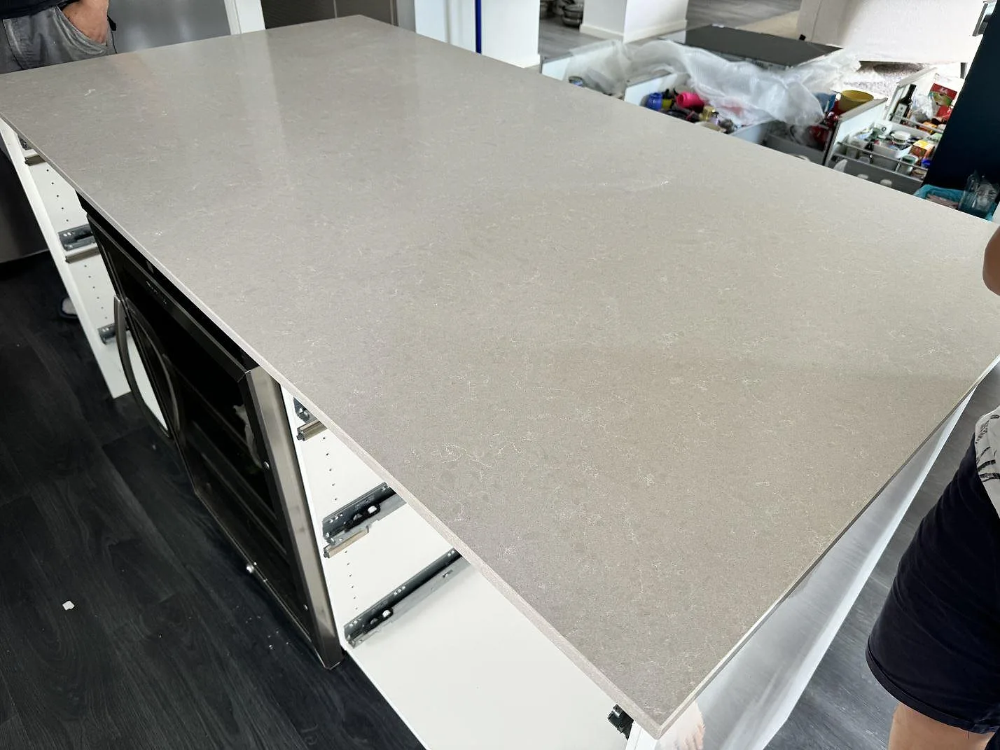 Stor arbetsyta i Technistone Noble Ivory White, polerad kvartskomposit, monterad på köksstommar under arbete i Staffanstorp.