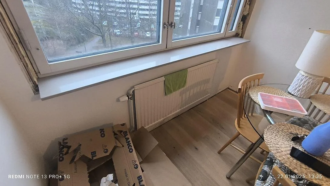 Fönsterbänk i polerad Technistone Noble Ivory White, ljus kvartskomposit vid ett större fönster under montering i Stockholm.