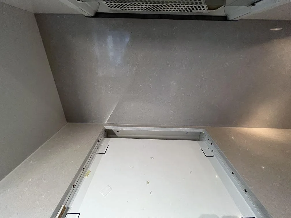 Väggbänk i polerad Technistone Noble Ivory White komposit med hällzon och stänkskydd i ett kök i Stockholm.