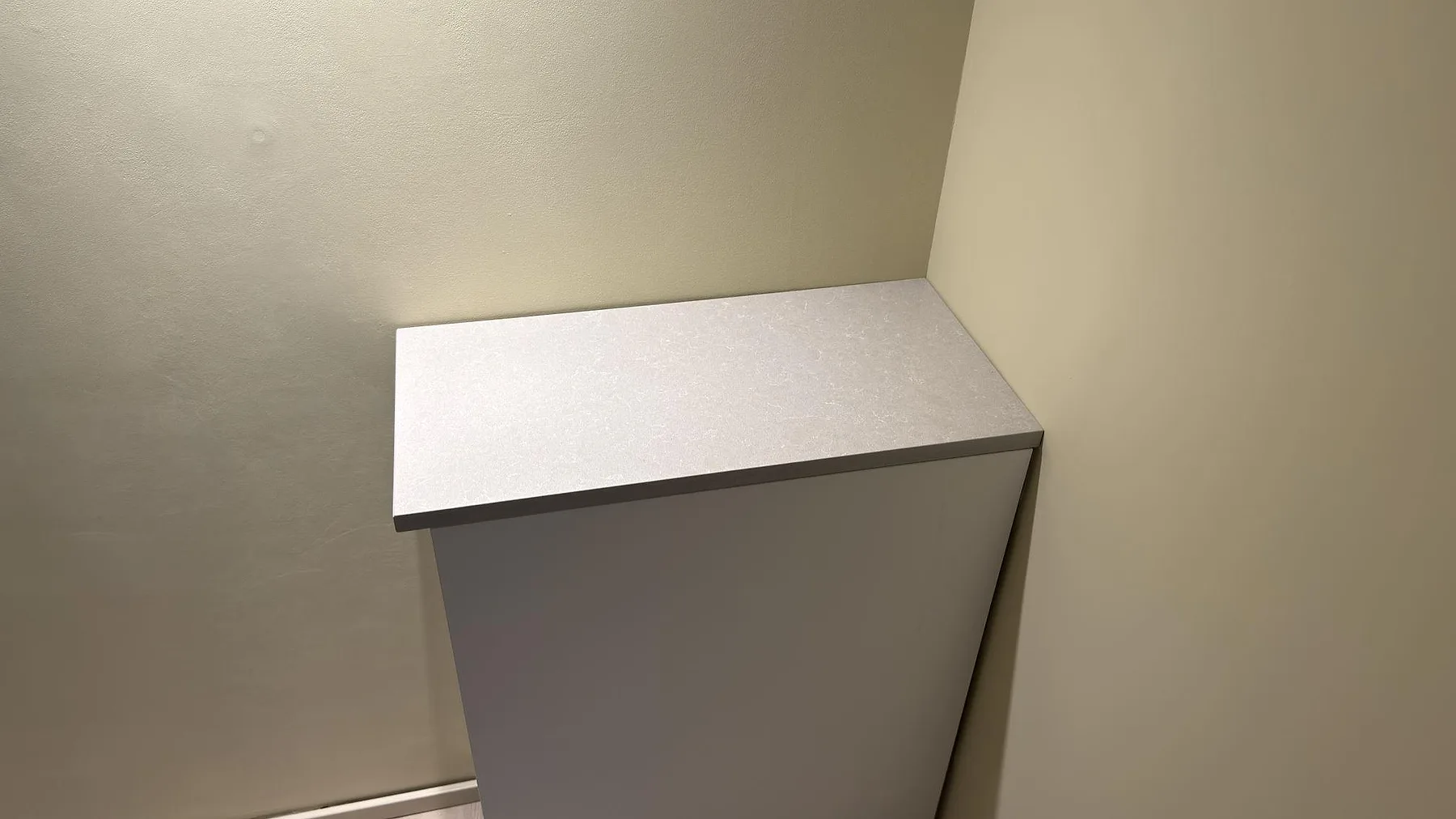 Mindre installerad skiva i Technistone Noble Ivory White kvartskomposit, polerad, monterad mot vägg i ett hem i Stockholm.