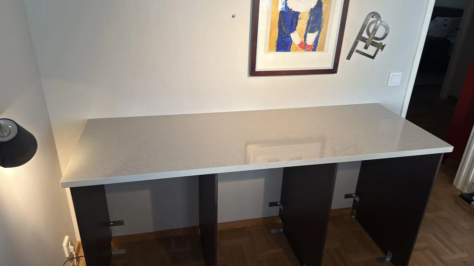 Bänkdel i polerad Technistone Noble Ivory White, 30 mm komposit, monterad på mörka stommar i Stockholm.