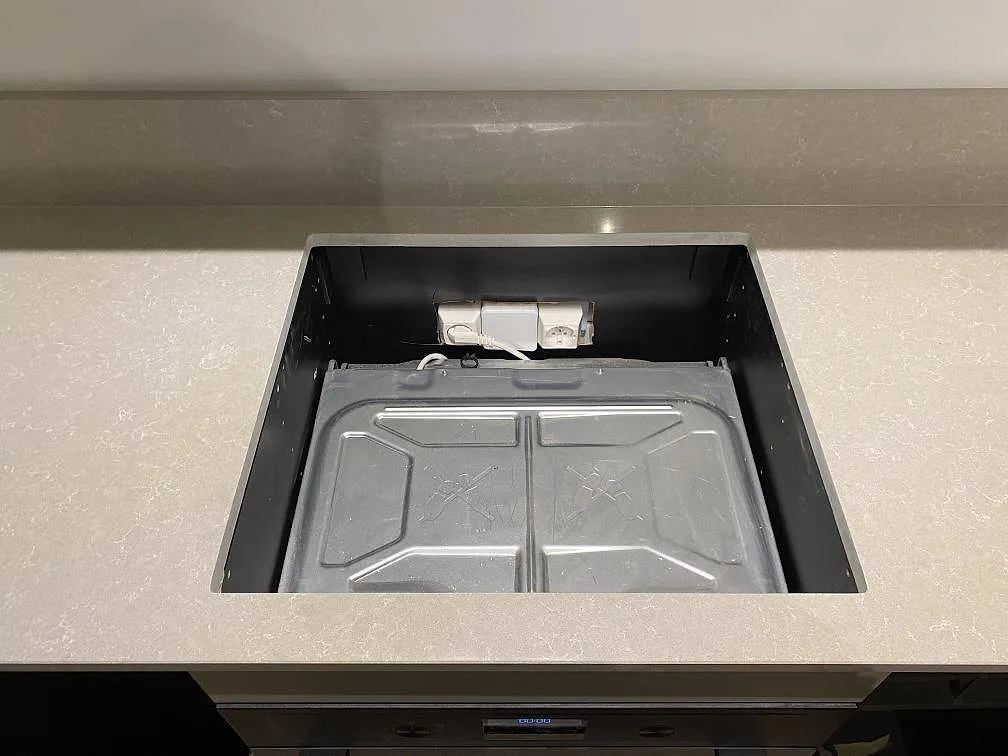 Topbild av köksbänkskiva i polerad Technistone Noble Ivory White med urtag för infälld köksmaskin, i ett kök i Stockholm under montering.
