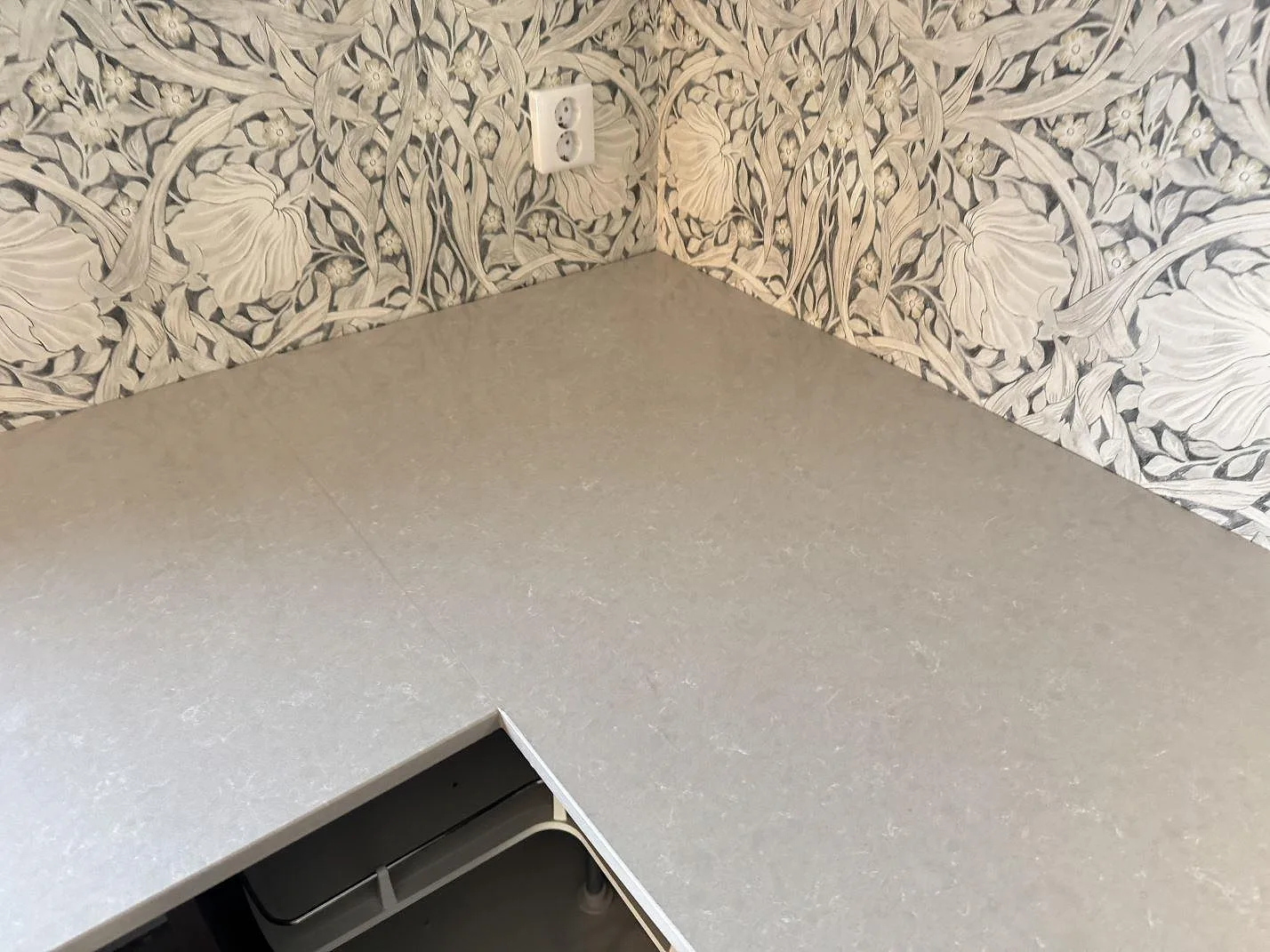 Närbild av den polerade ytan på Technistone Noble Ivory White, ljus kvartskomposit, monterad i ett kökshörn i Trelleborg.