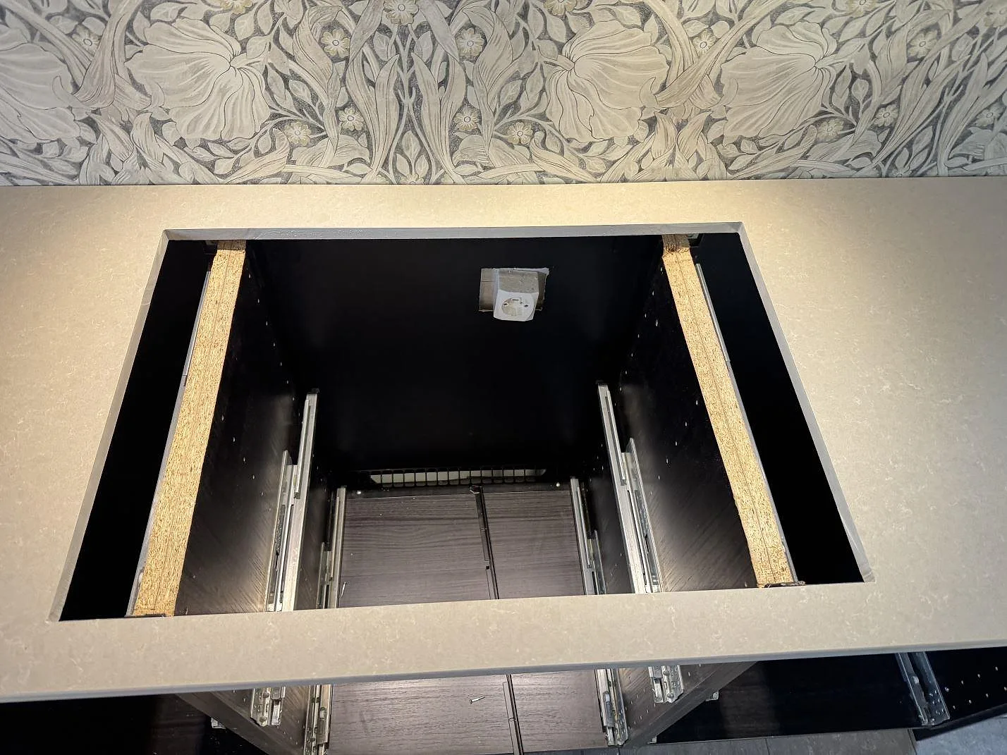 Detalj av rektangulärt urtag i köksbänkskiva av Technistone Noble Ivory White, polerad kvartskomposit, under montering i Trelleborg.