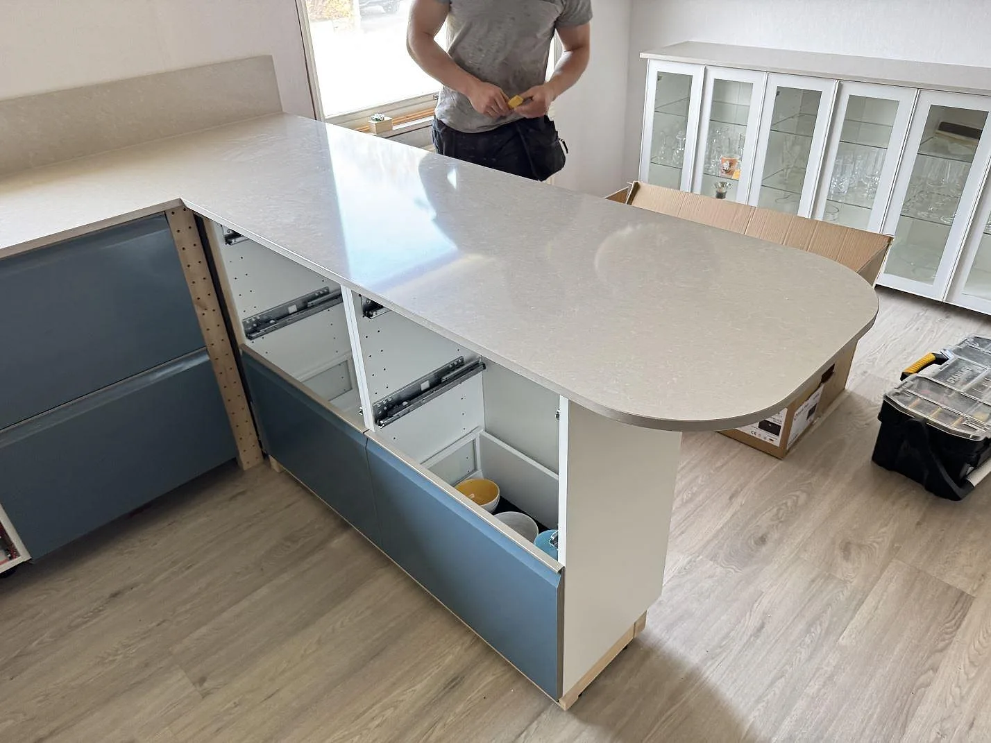 Köksbänkskiva i polerad Technistone Noble Ivory White på avrundad halvö under montering i ett kök i Trollhättan.